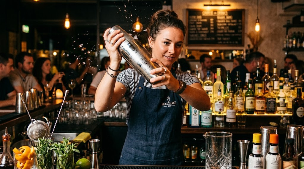 Bartender shaking a cocktail with a stainless steel shaker